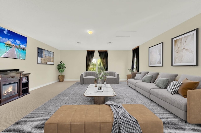 carpeted living area with a glass covered fireplace and baseboards