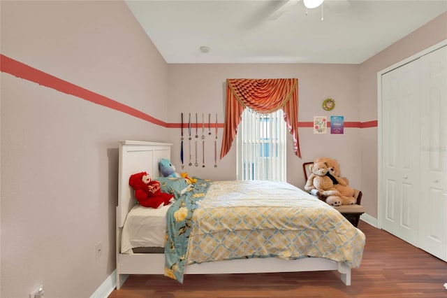 bedroom with wood finished floors, baseboards, a closet, and ceiling fan