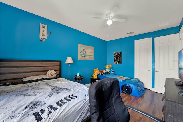 bedroom with a closet, visible vents, ceiling fan, and wood finished floors