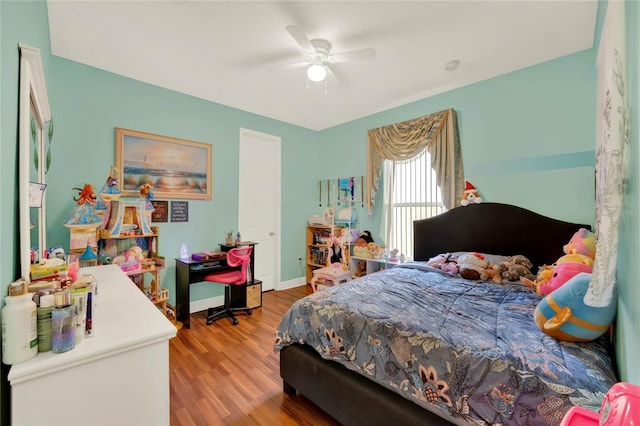 bedroom featuring ceiling fan, baseboards, and wood finished floors