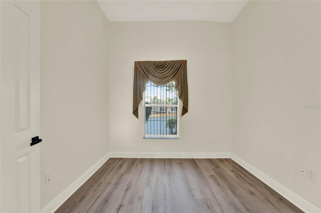 empty room with baseboards and wood finished floors