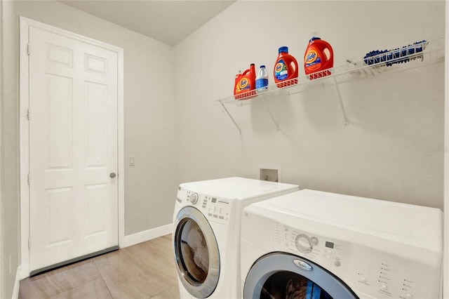 clothes washing area featuring baseboards, laundry area, and washing machine and clothes dryer