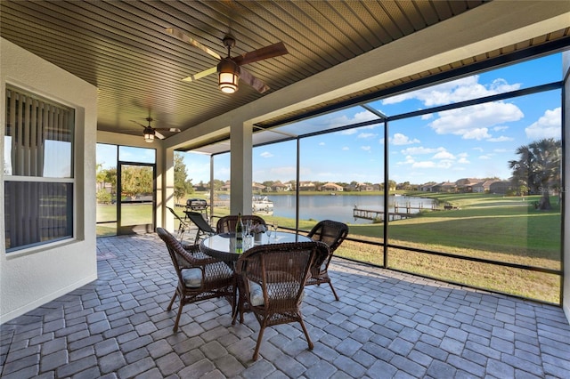 sunroom / solarium featuring a water view and a ceiling fan