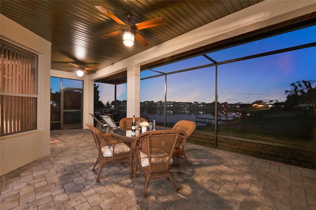 sunroom / solarium with a water view and ceiling fan