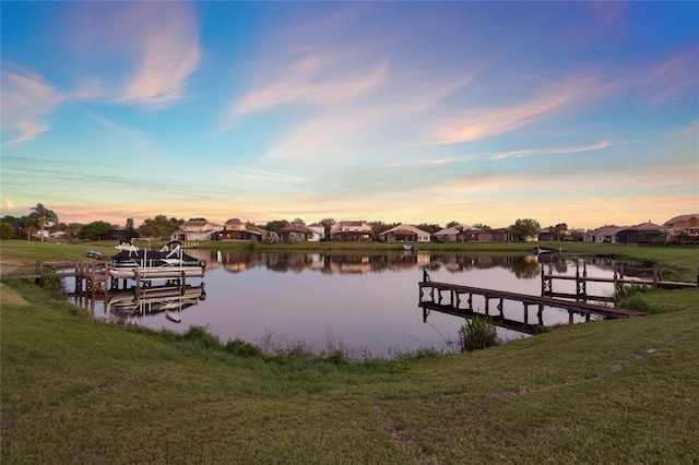 view of dock featuring a residential view, a water view, and a lawn