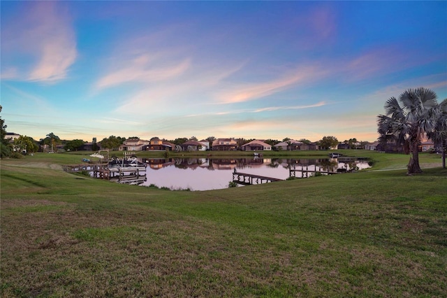 view of dock featuring a yard and a water view