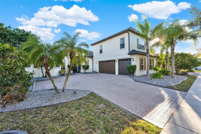 view of home's exterior with decorative driveway, a garage, and stucco siding