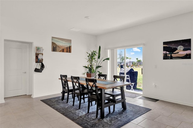 dining space with baseboards and light tile patterned flooring