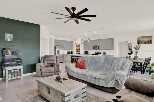 living room with light tile patterned flooring, recessed lighting, baseboards, and a ceiling fan