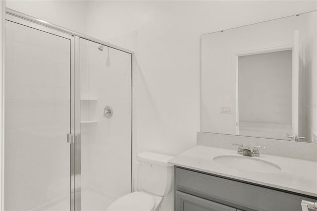 full bathroom featuring toilet, a stall shower, and vanity