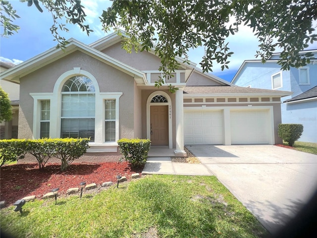 view of front of house with concrete driveway, a garage, and stucco siding