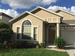 view of front facade featuring stucco siding, driveway, and a garage