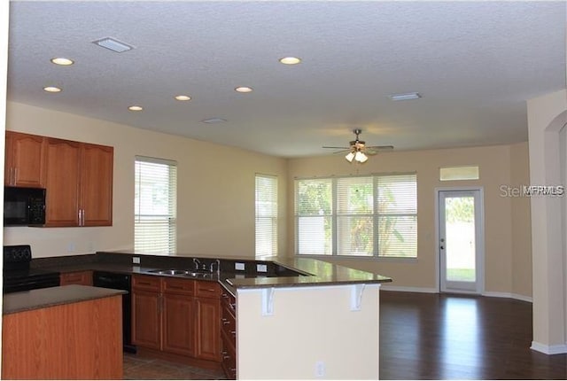 kitchen with visible vents, black appliances, a sink, a peninsula, and ceiling fan