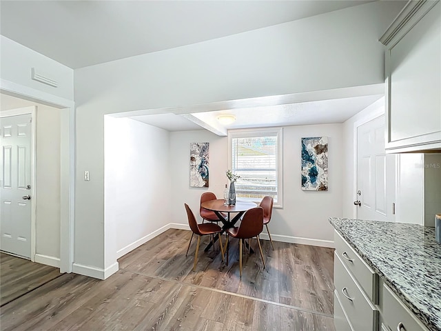 dining area featuring wood finished floors and baseboards