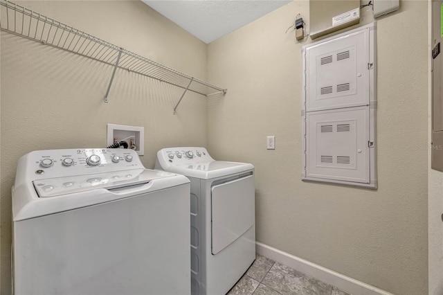 washroom with baseboards, washing machine and dryer, and laundry area