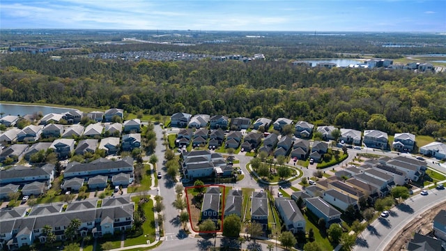 bird's eye view featuring a residential view, a wooded view, and a water view