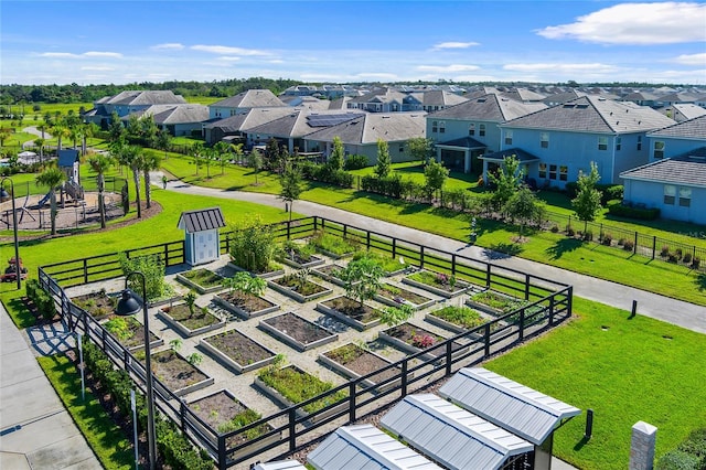 view of home's community with a garden, a lawn, and a residential view