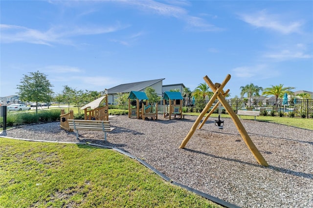 community play area featuring a lawn and fence