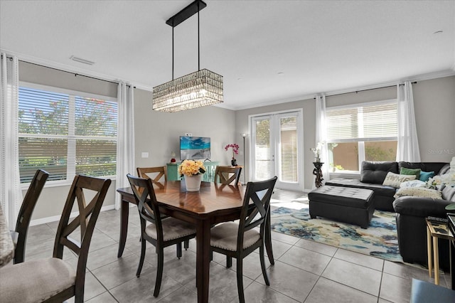 dining room with light tile patterned floors, visible vents, baseboards, and ornamental molding