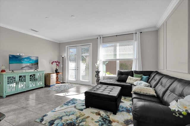 living area featuring tile patterned flooring, crown molding, french doors, and visible vents