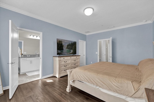 bedroom featuring baseboards, dark wood-type flooring, ornamental molding, and ensuite bathroom