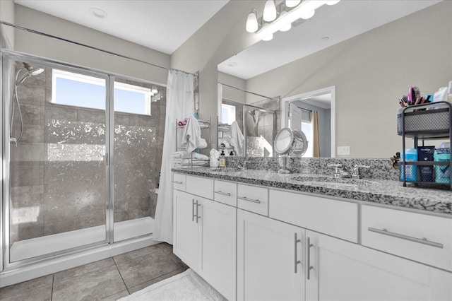 full bath featuring tile patterned flooring, a sink, a stall shower, and double vanity