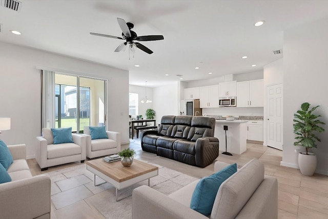 living room with a ceiling fan, visible vents, baseboards, light tile patterned flooring, and recessed lighting