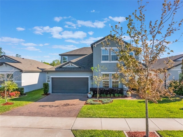 753 Daybreak Pl, Longwood, FL 32750 - view of front of home with a front yard, an attached garage, a shingled roof, stucco siding, and decorative driveway