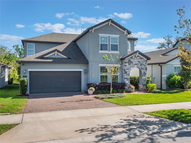 753 Daybreak Pl, Longwood, FL 32750 - view of front of house featuring roof with shingles, an attached garage, stucco siding, a front lawn, and decorative driveway