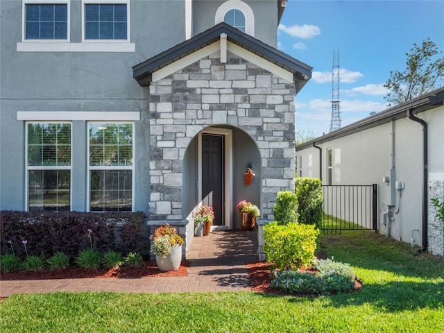 753 Daybreak Pl, Longwood, FL 32750 - property entrance with stucco siding, stone siding, and a lawn