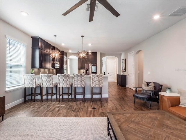 753 Daybreak Pl, Longwood, FL 32750 - kitchen with a breakfast bar area, a ceiling fan, a peninsula, arched walkways, and appliances with stainless steel finishes