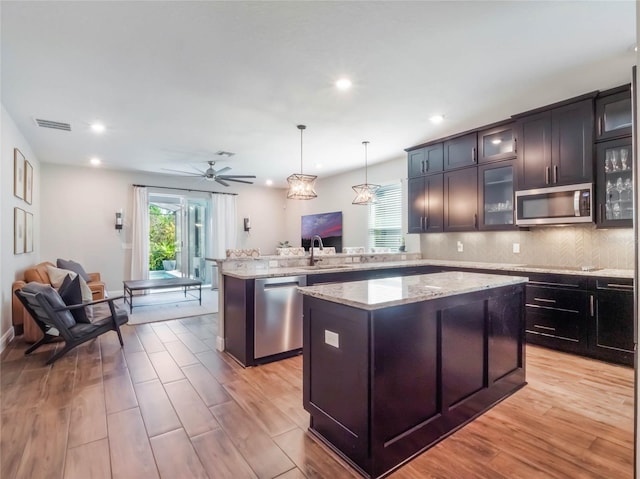 753 Daybreak Pl, Longwood, FL 32750 - kitchen with a peninsula, appliances with stainless steel finishes, open floor plan, and a center island