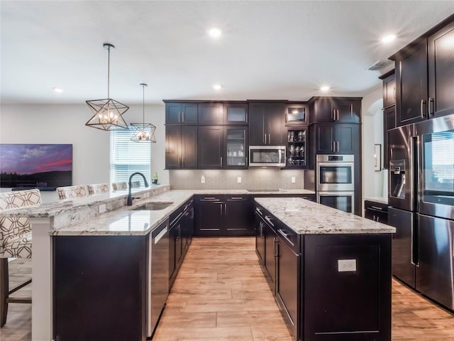 753 Daybreak Pl, Longwood, FL 32750 - kitchen with visible vents, a sink, a kitchen island, appliances with stainless steel finishes, and a peninsula