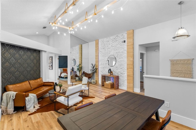 living area with baseboards, wood finished floors, rail lighting, and vaulted ceiling