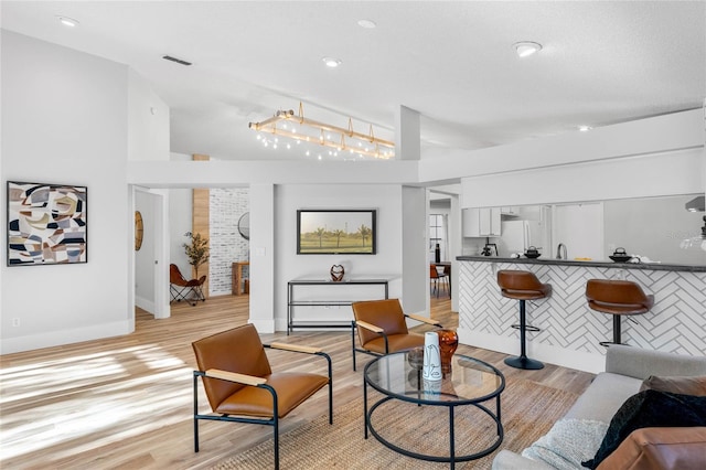 living room featuring visible vents, recessed lighting, baseboards, and light wood-style floors