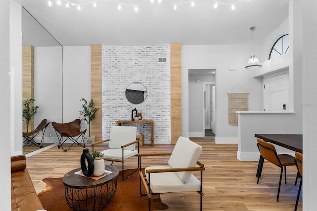 living area with rail lighting, baseboards, visible vents, and light wood finished floors