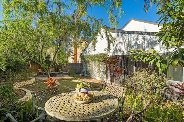 view of yard with outdoor dining area, a patio area, and a fenced backyard