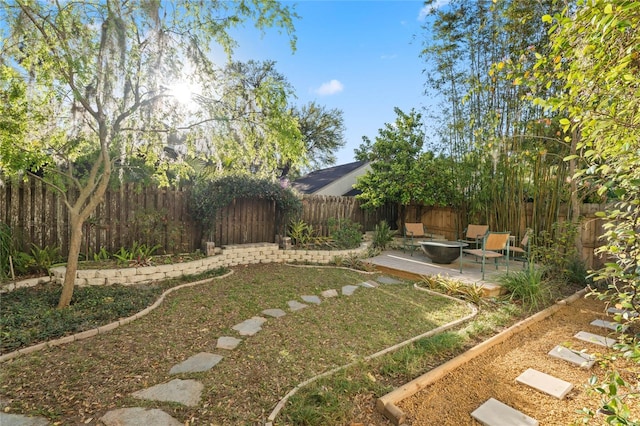 view of yard featuring a fenced backyard, an outdoor fire pit, and a patio