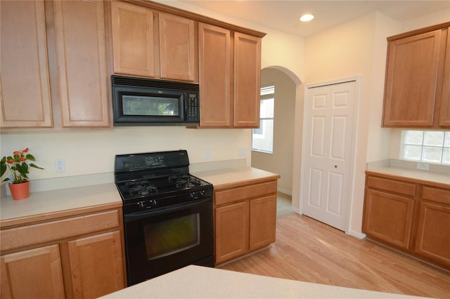 kitchen featuring recessed lighting, arched walkways, black appliances, light countertops, and light wood-style floors