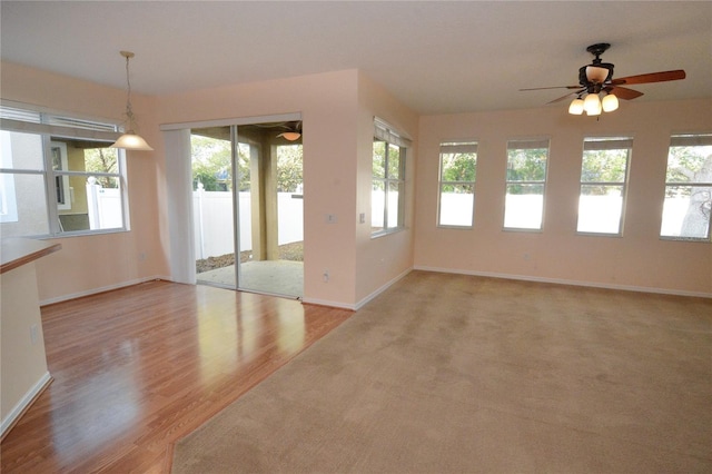 interior space featuring baseboards, a ceiling fan, and wood finished floors