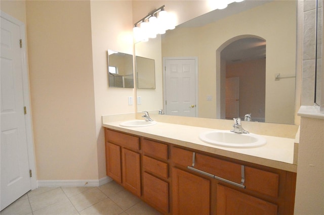 full bathroom featuring a sink, baseboards, double vanity, and tile patterned flooring