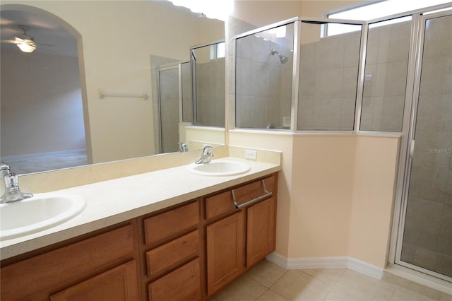 full bath featuring ceiling fan, a shower stall, tile patterned floors, and a sink