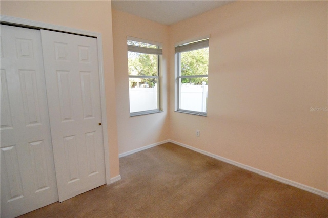 unfurnished bedroom with carpet, baseboards, and a closet