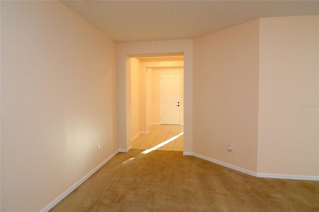 spare room featuring baseboards and carpet floors