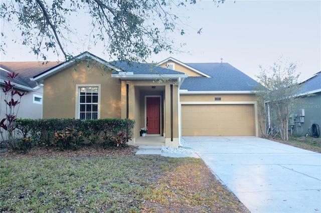 single story home with stucco siding, concrete driveway, and a garage