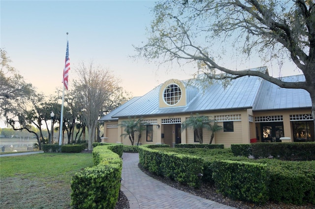 view of front of house with metal roof, a front lawn, and a standing seam roof