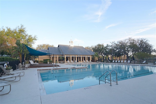 pool with a patio and fence