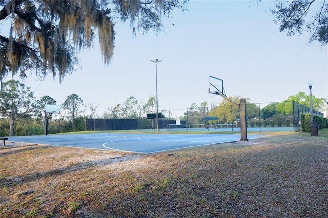 view of basketball court with a tennis court, community basketball court, and fence