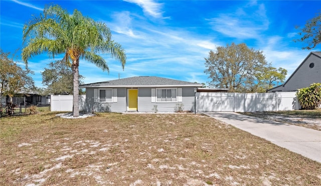 view of front of house with a front yard, driveway, and fence