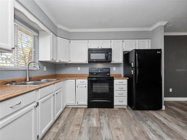 kitchen featuring a sink, black appliances, and white cabinets